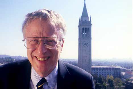 Smiling man wearing glasses with Campanile in background