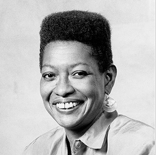 Black woman wearing earrings, smiling broad smile