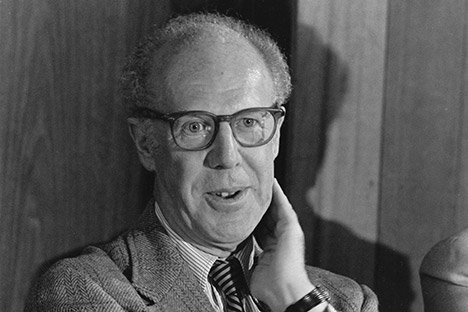 Man wearing glasses with hand on side of his neck