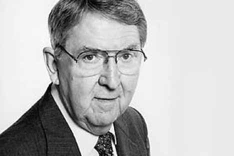 Black and white portrait photos of older white male wearing suit and tie and glasses