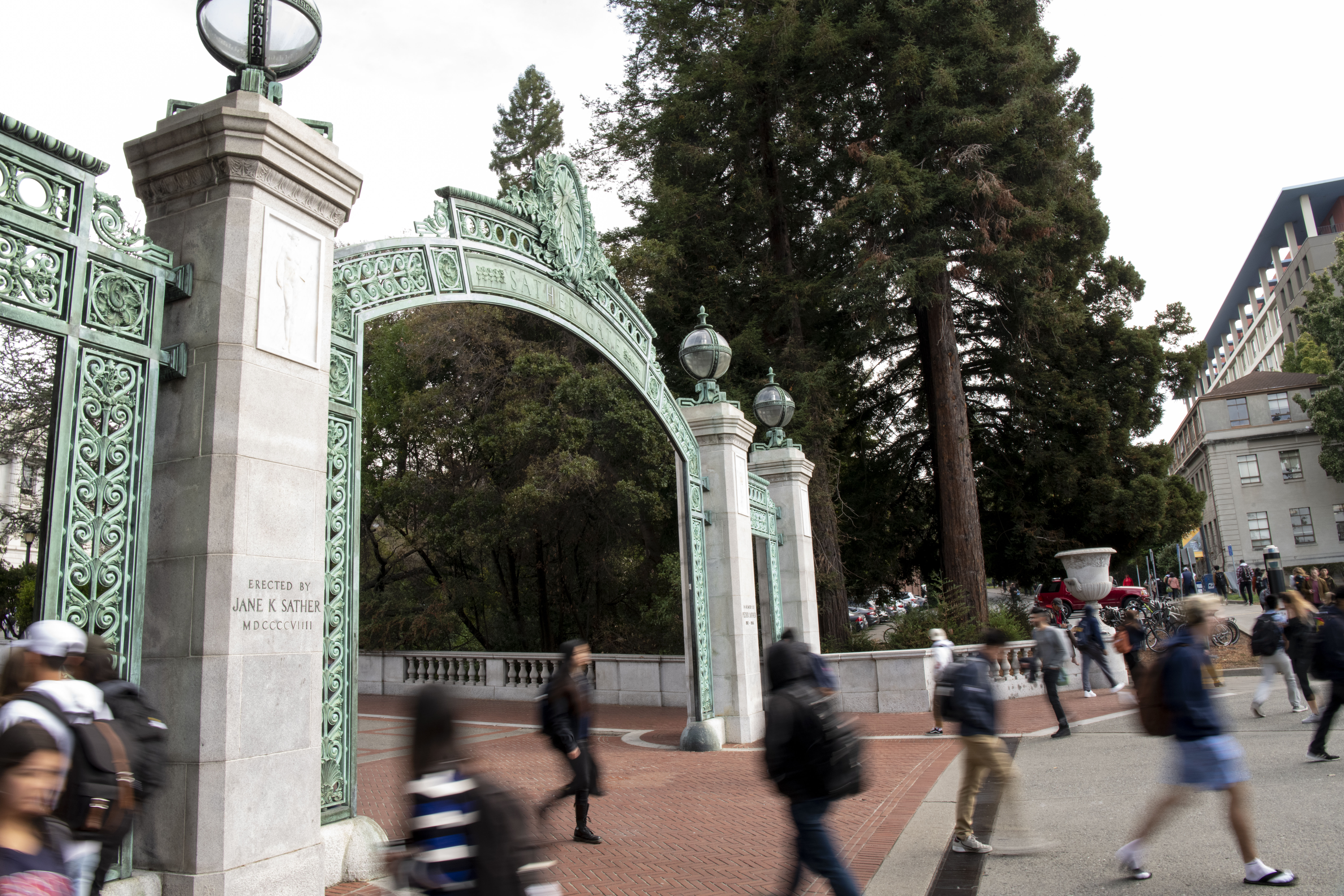 Long exposure image with a focused Sather Gate and blurred individuals walking through it