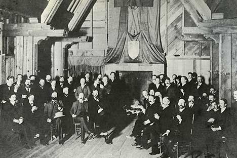 Large group of men sitting in a large meeting room