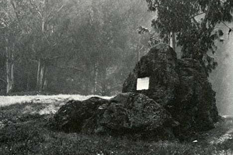 Historic black and white photo of Founder's Rock with a plaque mounted on it.