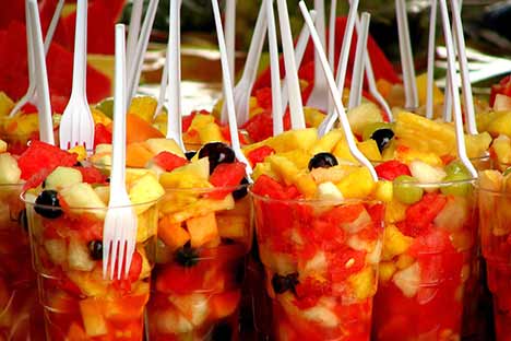 Cups filled with fruit cocktail and a fork