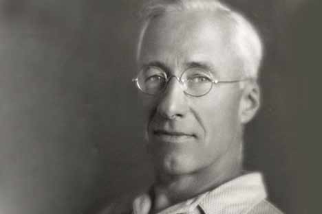 Black and white portrait of grey-haired man wearing glasses