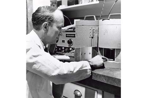 Man in lab coat operating a machine