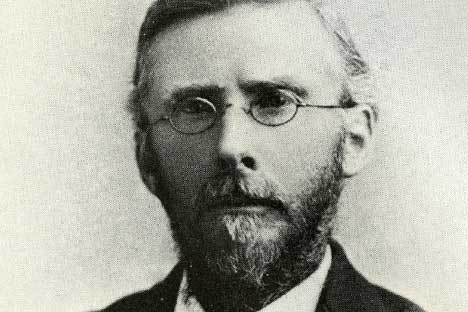 black and white portrait of bearded man wearing wire rim glasses