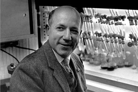 Man in suit in front of lab vials