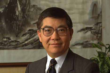 Dark haired man with glasses standing in front of East Asian art