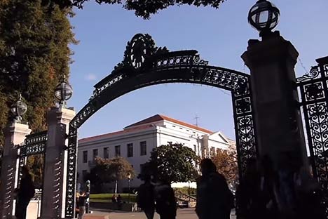 people walking through Sather Gate with Sproul Hall in background