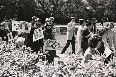 Protesters marching holding signs that read 'I oppose this war!'