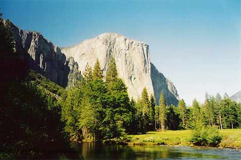 large granite rock face in valley with river